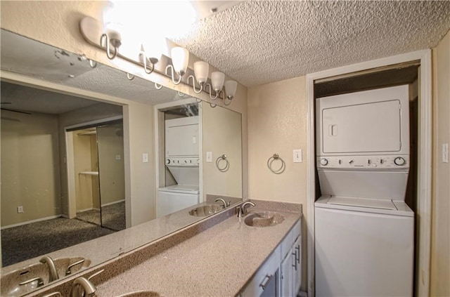 bathroom featuring double vanity, stacked washer / drying machine, and a textured ceiling