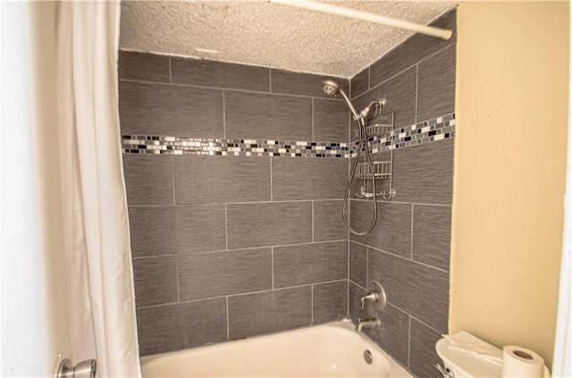 bathroom with a textured ceiling, toilet, and shower / bath combo with shower curtain