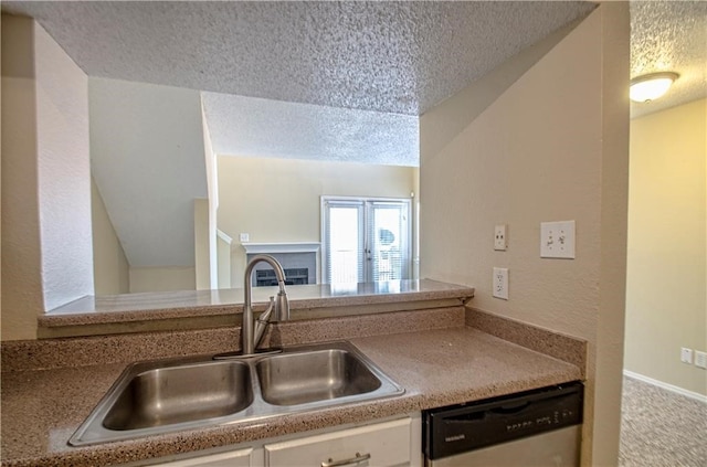 kitchen featuring sink, stainless steel dishwasher, and a textured ceiling