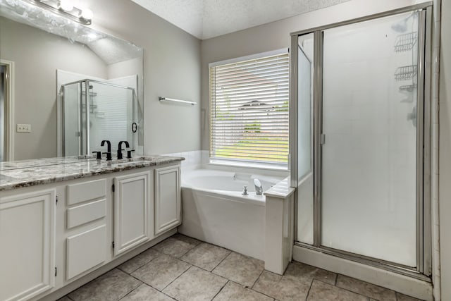 bathroom featuring vanity, tile patterned floors, independent shower and bath, and a textured ceiling