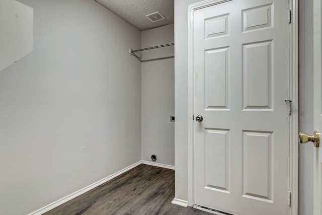 laundry room with dark hardwood / wood-style floors, a textured ceiling, and electric dryer hookup