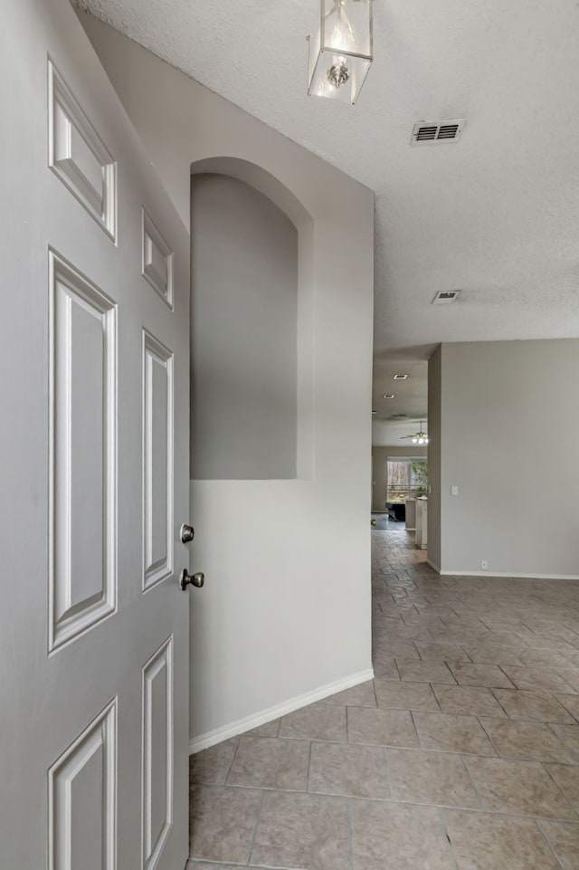 interior space featuring a textured ceiling and light tile patterned floors