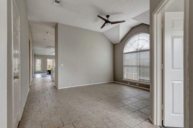 empty room with a textured ceiling, vaulted ceiling, and ceiling fan