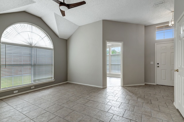 foyer with vaulted ceiling, a textured ceiling, and ceiling fan