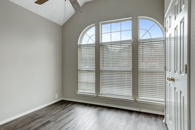 empty room featuring vaulted ceiling, dark hardwood / wood-style floors, and ceiling fan