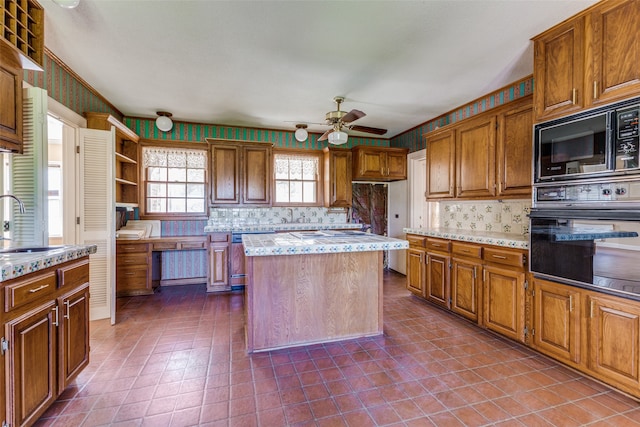 kitchen featuring a center island, tile patterned flooring, ceiling fan, and black appliances