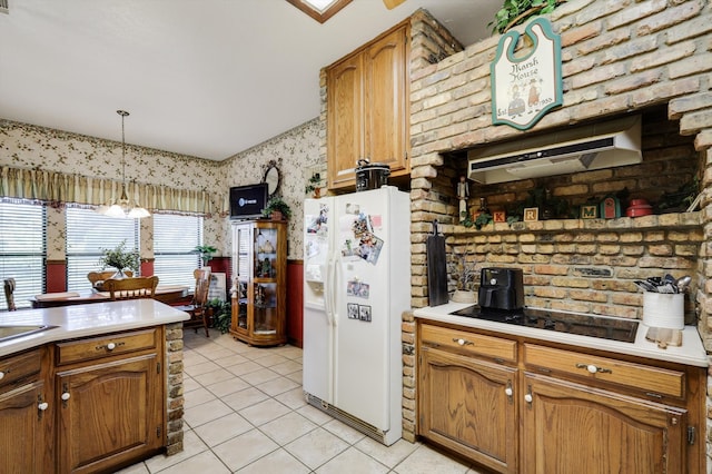 kitchen with light tile patterned flooring, brick wall, white refrigerator with ice dispenser, and hanging light fixtures