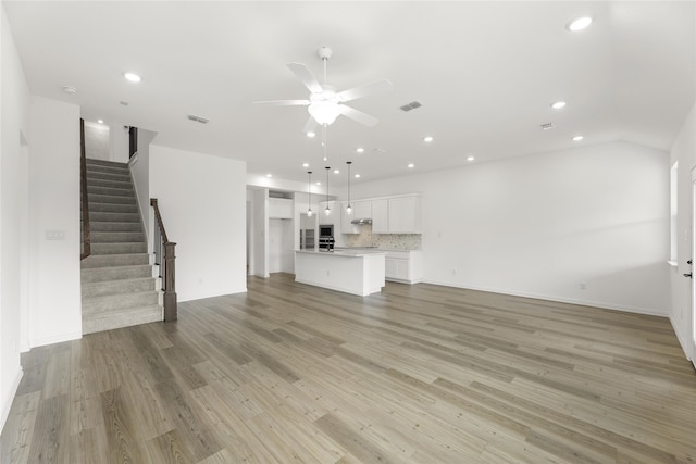 unfurnished living room with ceiling fan and light wood-type flooring