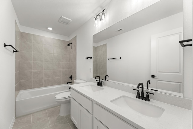 full bathroom featuring tile patterned flooring, tiled shower / bath, vanity, and toilet