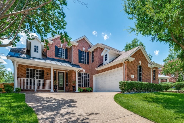 view of front of home featuring a garage, a front yard, and covered porch