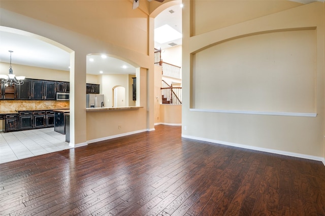 unfurnished living room featuring light hardwood / wood-style flooring and a chandelier