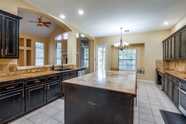 kitchen with backsplash, sink, dishwasher, a center island, and lofted ceiling