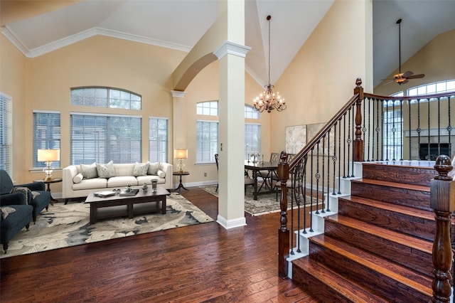 living room featuring ornate columns, dark hardwood / wood-style floors, ceiling fan with notable chandelier, and high vaulted ceiling