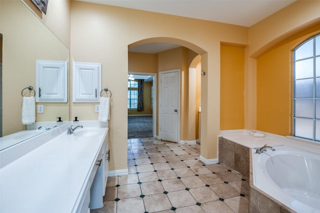 bathroom with vanity and tiled tub