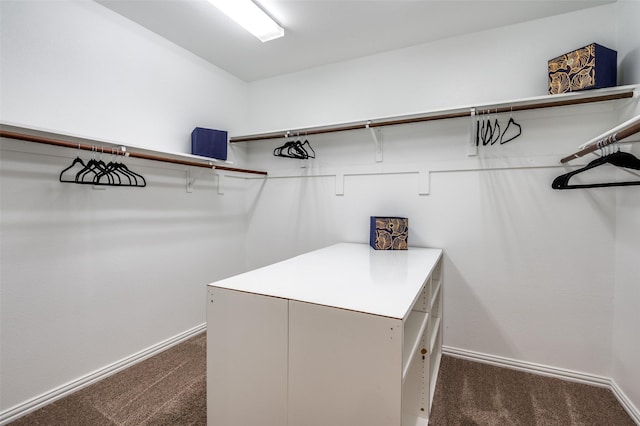 walk in closet featuring dark carpet