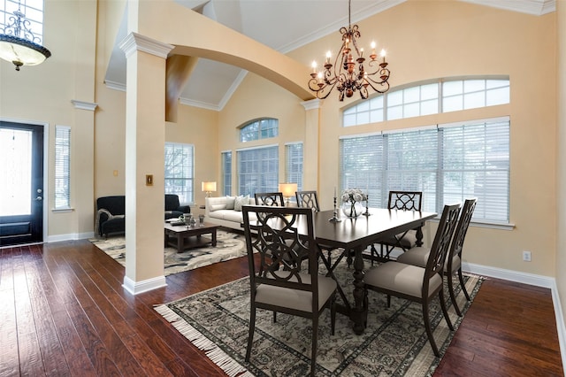 dining space with high vaulted ceiling, dark hardwood / wood-style floors, decorative columns, and a notable chandelier