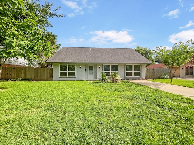 ranch-style house with fence and a front lawn