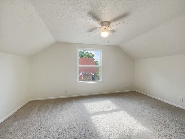 bonus room featuring lofted ceiling, baseboards, carpet floors, and a textured ceiling