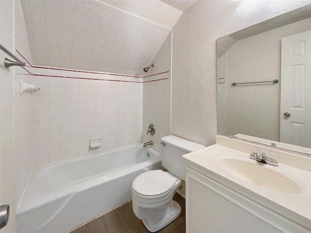 full bath featuring a textured wall, toilet, washtub / shower combination, vanity, and wood finished floors