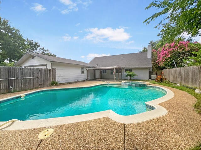 view of swimming pool featuring a patio area, a fenced backyard, and a pool with connected hot tub