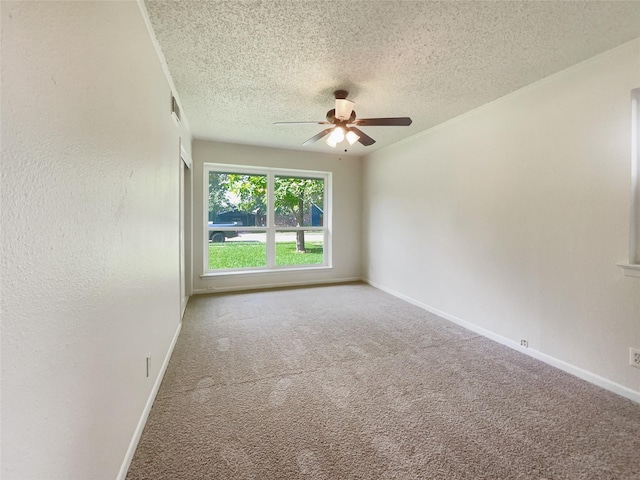 unfurnished room featuring a textured ceiling, carpet, and baseboards