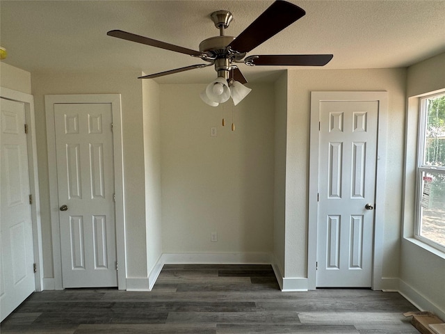 unfurnished bedroom featuring ceiling fan and dark wood-type flooring