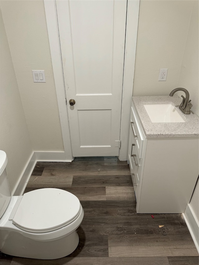 bathroom with toilet, vanity, and hardwood / wood-style flooring