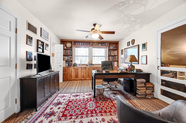 office area featuring built in shelves and ceiling fan