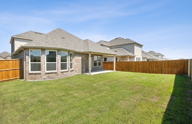 rear view of property with a lawn and a patio