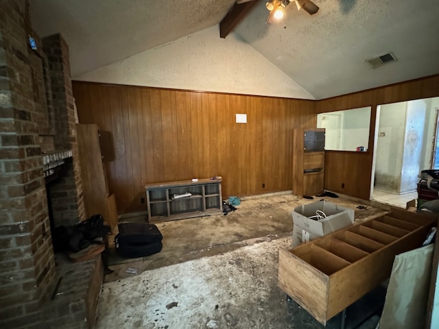 living room featuring ceiling fan, lofted ceiling with beams, a textured ceiling, and a brick fireplace