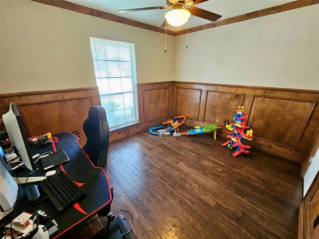 recreation room with dark hardwood / wood-style flooring, ornamental molding, and ceiling fan