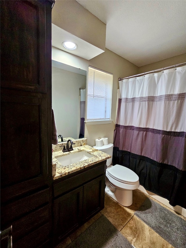 bathroom with a shower with curtain, vanity, toilet, and tile patterned flooring