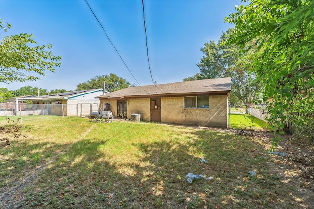 back of property featuring a yard and fence