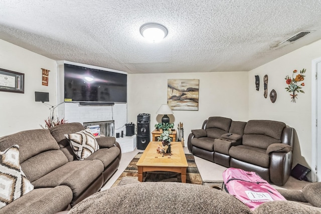 living area featuring carpet flooring, visible vents, and a textured ceiling