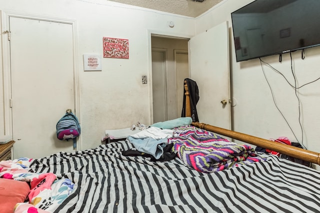 bedroom featuring ornamental molding, a closet, and a textured ceiling