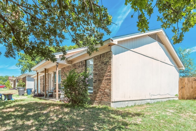 view of side of home with a yard