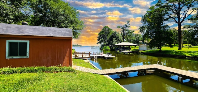 dock area featuring a water view and a lawn