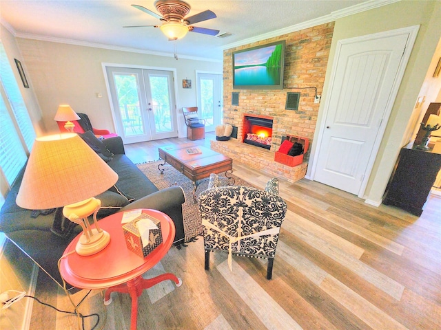 living room featuring wood-type flooring, a fireplace, french doors, and crown molding