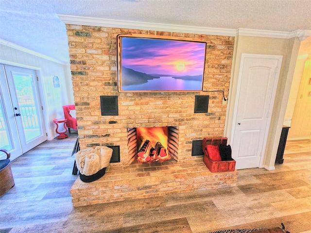 living room with a fireplace, a textured ceiling, crown molding, and hardwood / wood-style floors