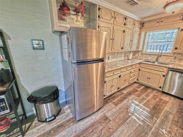 kitchen featuring appliances with stainless steel finishes, tasteful backsplash, sink, crown molding, and dark wood-type flooring