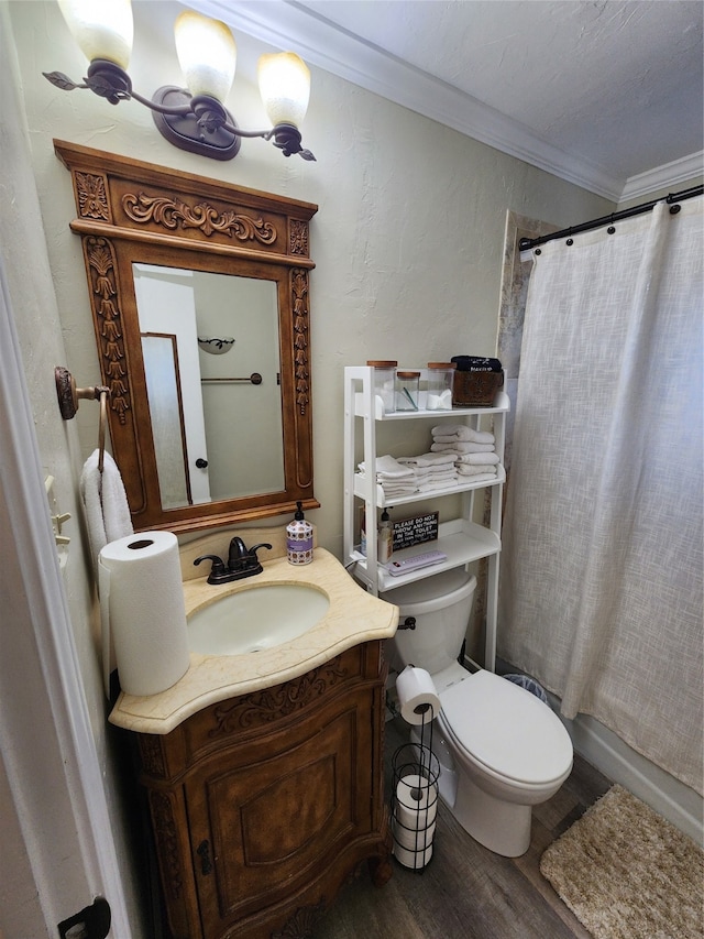 bathroom with vanity, crown molding, wood-type flooring, and toilet