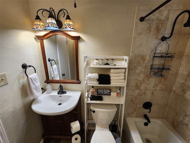 full bathroom featuring vanity, tiled shower / bath combo, and toilet