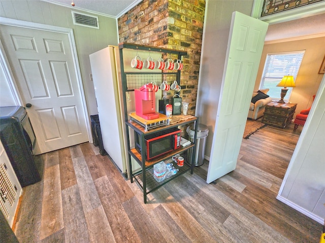 corridor with hardwood / wood-style flooring and ornamental molding