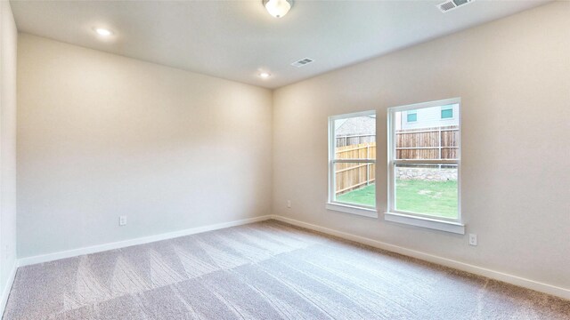 carpeted empty room with recessed lighting, visible vents, and baseboards