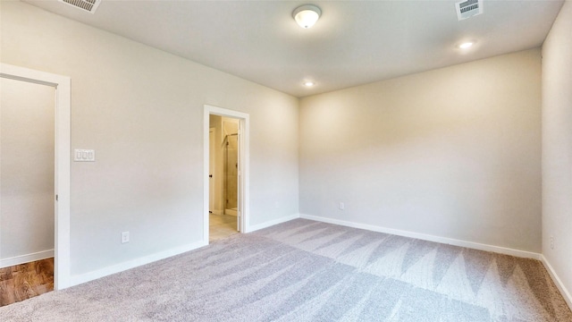 empty room featuring light carpet, baseboards, visible vents, and recessed lighting