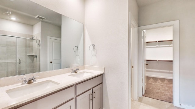 bathroom with tile patterned floors, vanity, and a shower with shower door