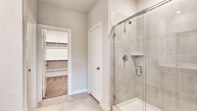 bathroom with tile patterned floors and a shower with door