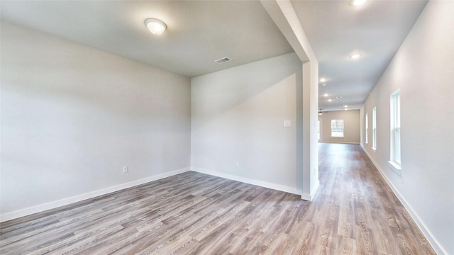 unfurnished room with visible vents, baseboards, and wood finished floors