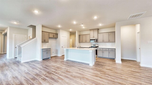 kitchen with light wood finished floors, gray cabinets, visible vents, and stainless steel appliances