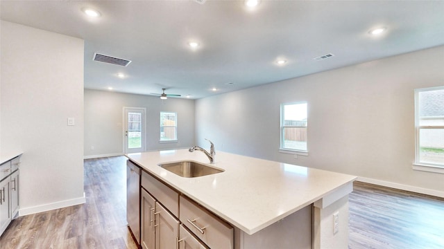 kitchen featuring stainless steel dishwasher, visible vents, open floor plan, and a sink